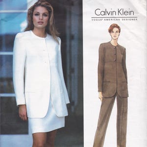 May include: The image shows a white skirt suit and a brown trouser suit. The white suit has a long, buttoned jacket and a matching skirt. The brown suit features a long, buttoned jacket and matching trousers. The Calvin Klein logo is displayed.
