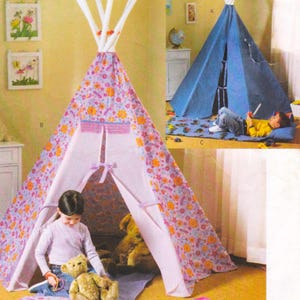 May include: A children's teepee tent with a floral pattern in shades of purple, orange, and yellow. The tent has a white interior and is decorated with ribbons. A child is sitting inside the tent with a teddy bear.