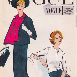 May include: Vintage Vogue magazine cover featuring two women in stylish outfits. One model wears a dark suit with a pink blouse and a wide-brimmed hat. The other model is in a white cardigan and dark skirt. The magazine title is visible.
