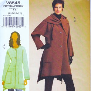 May include: A sewing pattern for a coat, with the text "V8545" and size information. The image shows a woman wearing a brown coat with a hood and large buttons. A second coat design is shown in light green.