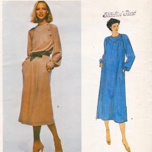 May include: A sewing pattern envelope titled Stitchin' Time featuring a beige long-sleeved dress with a belted waist and side pockets, alongside a blue illustrated version of the same dress design with a yoke neckline and button details.