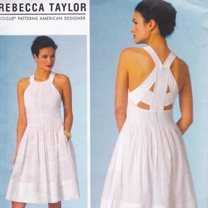 Peut inclure: Une robe blanche à col licou avec une jupe plissée et un dos original. La robe présente un corsage ajusté et une jupe évasée. Le texte "REBECCA TAYLOR" et "VOGUE PATTERNS AMERICAN DESIGNER" est également visible.
