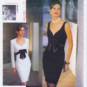 May include: Two elegant dresses are featured in this image. One is a long-sleeved white dress with a black bow at the waist. The other is a black sleeveless dress with a V-neck and a black bow at the waist. The image is from a fashion magazine.