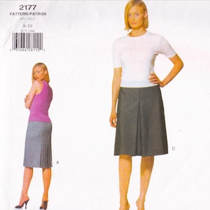 May include: A sewing pattern package showing a woman in a white top and a grey skirt with pleats. The pattern is labelled 2177 and is sized 8-10. The image also shows a woman in a pink top and grey skirt.