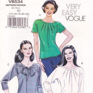 May include: Vogue pattern V8534 shows illustrations of three different blouses. The pattern includes sizes E5 (UK 14-16-18-20-22). The blouses are a green short-sleeve top, a grey top with a bow, and a white long-sleeve top.