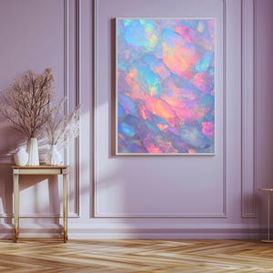 Puede incluir: Impresión artística abstracta con una vibrante exhibición de colores. La obra presenta una mezcla de tonos rosas, azules y amarillos, creando un efecto luminoso y texturizado. La pieza está enmarcada en un borde blanco.