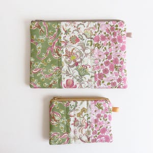 May include: Two patchwork fabric zippered pouches, one larger than the other. Both pouches are made of green and pink floral patterned fabric. The larger pouch has a light pink zipper pull, and the smaller pouch has a tan zipper pull.