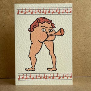 May include: A quirky greeting card illustration of a figure with a trumpet, in peach and brown tones. The figure has red curly hair and is playing a trumpet. Red musical notes decorate the top and bottom edges of the card.