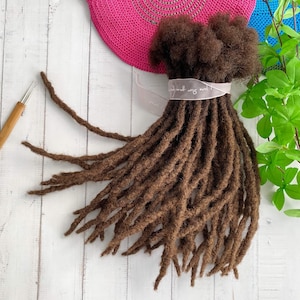 Peut inclure: Un paquet de dreadlocks en cheveux humains bruns, également appelés faux locs, pour extensions de cheveux. Les dreadlocks sont disposées en éventail et sont prêtes à être installées.