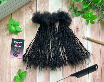 May include: Black loc extensions arranged on a wooden surface, with a black comb and a small tool. A business card with the text "Premium Loc Designs" and an illustration of a person with locs is also present. Green leaves and a white structure are in the background.