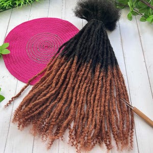 Peut inclure: Un ensemble de dreadlocks synthétiques ombrés brun et noir. Les dreadlocks sont longues et épaisses, et elles sont disposées en un paquet lâche. Les dreadlocks sont faites de cheveux synthétiques et sont conçues pour être utilisées comme extensions de cheveux.