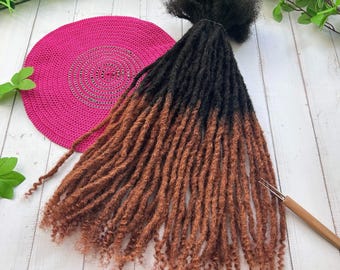 May include: A set of brown and black ombre synthetic dreadlocks. The dreadlocks are long and thick, and they are arranged in a loose bundle. The dreadlocks are made of synthetic hair, and they are designed to be used for hair extensions.