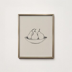 Könnte beinhalten: Ein gerahmter Druck mit einer Feder- und Tuschzeichnung von drei Birnen in einer Schüssel. Die Birnen sind hell gefärbt mit dunklen Stielen, und die Schüssel hat ein einfaches, geschwungenes Design. Der Rahmen ist goldfarben.