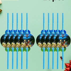 May include: Blue plastic straws with decorative toppers featuring a cartoon scene. The image shows two sets of straws, each with a circular topper and ten straws. The text "Straws 10pcs" is visible.