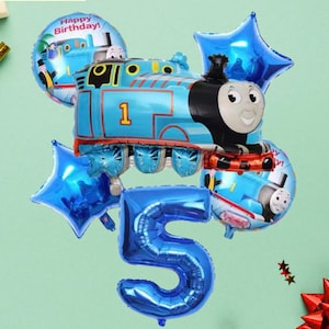 Könnte beinhalten: Eine Ansammlung blauer Folienballons in Form einer Lokomotive, Sterne und der Zahl 5. Der Lokomotivballon trägt die Nummer 1 und ein Ballon mit der Aufschrift "Happy Birthday!". Der Hintergrund ist hellgrün.