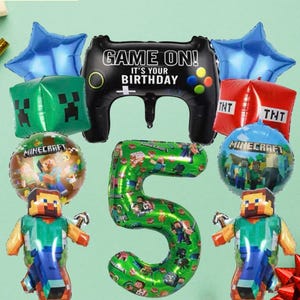 May include: A collection of Minecraft-themed birthday balloons. Includes a black controller-shaped balloon with "Game On! It's Your Birthday" text, a green number 5 balloon, and character balloons. Also includes blue star and red TNT balloons.