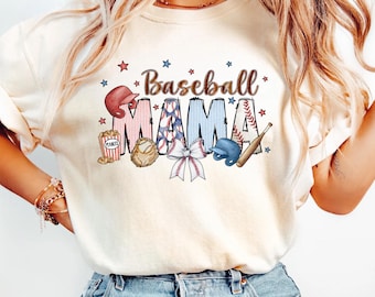 Op de afbeelding: Een vrouw draagt een wit T-shirt met de tekst "Baseball Mama" in rood, blauw en wit. De tekst wordt omringd door illustraties met een baseballthema, waaronder een honkbal, knuppel, handschoen en een popcorn-emmer. Het shirt is ivoor van kleur.
