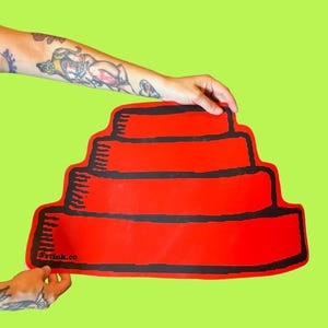 May include: A red, tiered, cake-shaped object with black horizontal stripes. The object is held against a lime green background. The text "@stink.co" is visible on the bottom left of the object.