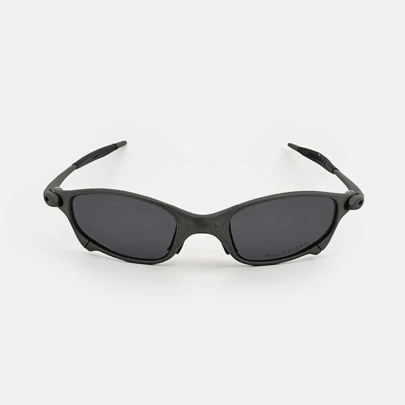 May include: Black sunglasses with a streamlined design. The sunglasses have dark lenses and a matte black frame. The arms are slender and curve gently. The overall style is modern and sporty, suitable for various activities.
