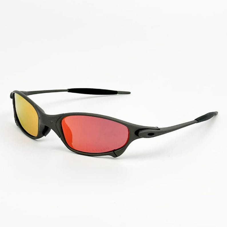 May include: Black sunglasses with a sleek design. The lenses have a yellow to red gradient. The frames are matte black, and the arms curve for comfort. A stylish accessory for eye protection. The sunglasses are suitable for both men and women.