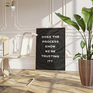 Op de afbeelding: Zwart-wit typografieposter met de tekst "Does the process know we're trusting it?" op een zwarte achtergrond met witte golvende lijnen.