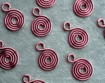 Pequeñas espirales de alambre de cobre, dijes o colgantes con forma de espiral hechos a mano por artesanos.