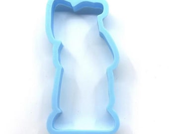 May include: A light blue plastic cookie cutter shaped like a person. The number "1021" is printed at the top. The cutter has a rounded top and a flared base, ideal for baking biscuits.