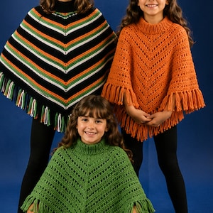 May include: Three knitted ponchos with high collars and fringe trim. One poncho features black, white, orange, and green chevron stripes. Another is solid orange with a vertical open-stitch pattern. The third is solid green with a similar pattern.