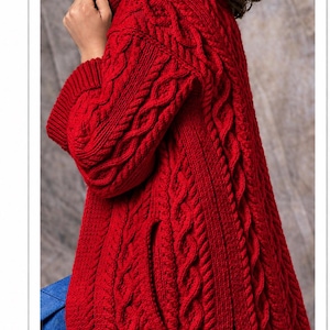 May include: A vibrant red cable-knit sweater featuring a high turtleneck collar, long sleeves with ribbed cuffs, and a side slit detail. The garment is constructed with a thick, textured knit pattern that runs vertically along the body and sleeves.