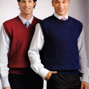 May include: Two people wearing V-neck sweater vests. One vest is a deep red, the other is navy blue. Both are worn over white collared shirts and ties. The people are also wearing black dress pants.