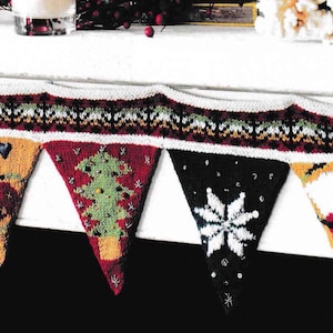 May include: A knitted Christmas banner with triangular flags. Each flag features festive designs like snowflakes, Christmas trees, and holiday ornaments. The banner's top edge has a patterned border in red, white, and green.