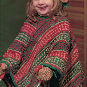 May include: A child wearing a handmade crochet poncho, hat, and mittens set. The poncho is red, green, and tan with a geometric pattern. The hat has a long, pointed end with pom-poms. The mittens are tan.