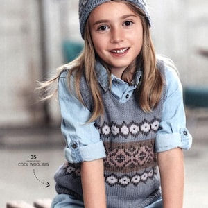 May include: A young person wearing a gray knit hat with a pom-pom and a matching patterned sweater vest over a denim shirt. The vest features a geometric design in brown and white. The text "COOL WOOL BIG" is visible.