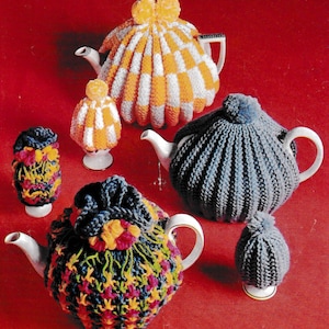 May include: A selection of hand-knitted tea cosies in different designs and colours. The image shows an orange and white checked cosy, a blue knitted cosy with a pom-pom, and a colourful floral cosy. The cosies are designed to fit teapots and tea cups.