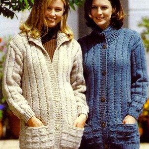 May include: Two women wearing long, knitted cardigans. One is a light beige color, and the other is a medium blue. Both cardigans have pockets and button closures. The beige cardigan has a collared neckline, while the blue one has a turtleneck.
