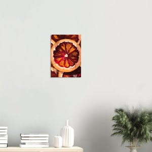 Op de afbeelding: Schilderij van een plak bloedsinaasappel. Het kunstwerk toont een levendige oranje schil met een dieprood en oranje interieur. De stijl is impressionistisch, met zichtbare penseelstreken en een focus op kleur en textuur.