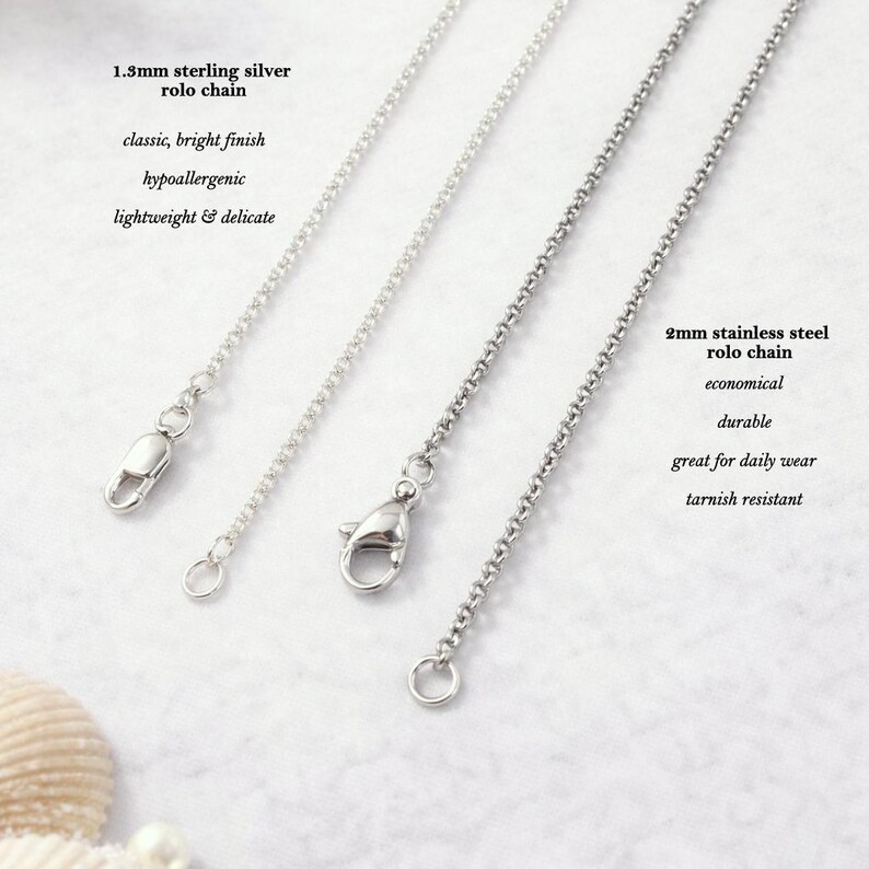 three different types of silver chain necklaces, each with a unique clasp design, arranged side by side.