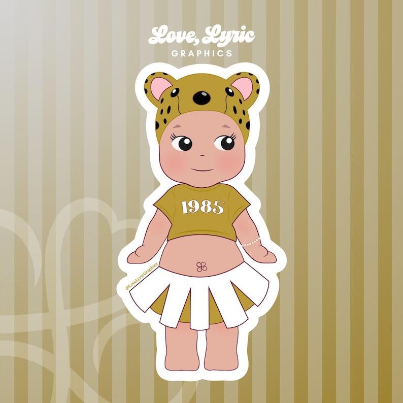 May include: A sticker featuring a cartoon baby wearing a gold crop top with "1985" printed on it, a white skirt, and a leopard print hat. The sticker has the text "Love, Lyric GRAPHICS" in the top left corner.