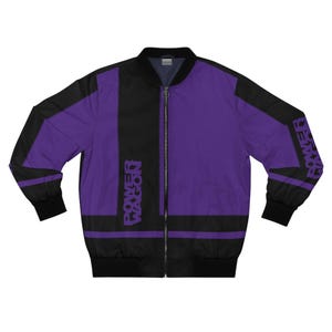 May include: A purple and black bomber jacket with the text "POWER WAGON" printed vertically on the front and on the right sleeve. The jacket has a black zipper and black cuffs and trim.