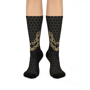 May include: Black socks with a gold phoenix design. The socks have a honeycomb pattern in gold and black. The phoenix is centered on the front of the socks, with the honeycomb pattern extending down the leg.