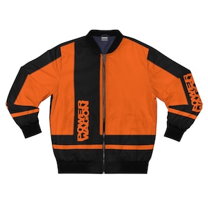 May include: Orange and black bomber jacket with the text "POWER WAGON" printed in orange. The jacket has a black collar, cuffs, and hem. The jacket is zipped up and has a black zipper.