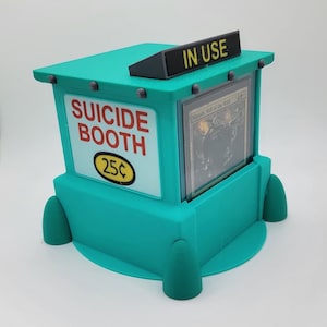Könnte beinhalten: Ein türkisfarbener Stand mit den Worten "SUICIDE BOOTH" in Rot und einem 25¢-Schild. Der Stand hat ein schwarzes Schild mit der Aufschrift "IN USE" und eine Karte ist darin sichtbar. Der Stand hat einen abgerundeten Sockel.