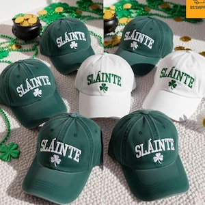 May include: Green and white baseball caps, each embroidered with the word "Sláinte" and a shamrock. The caps are displayed with St. Patrick's Day decorations, including gold coins and green beads.