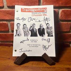Könnte beinhalten: Eine weiße Drehbuchseite aus dem Film Trainspotting mit Unterschriften der Besetzung. Der Text lautet "Wähle deine Zukunft. Wähle das Leben." und "Drehbuch von John Hodge" und "Basierend auf Trainspotting von Irvine Welsh".