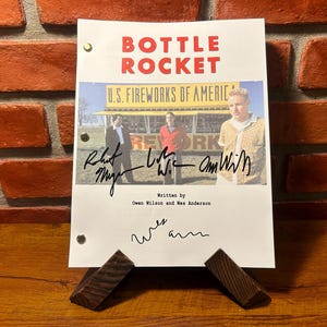 Könnte beinhalten: Ein weißes Drehbuch für den Film "Bottle Rocket" mit dem Titel "U.S. Fireworks of America" und Unterschriften von Owen Wilson, Luke Wilson und  "Ann Wilson". Das Drehbuch wurde von Owen Wilson und Wes Anderson geschrieben.