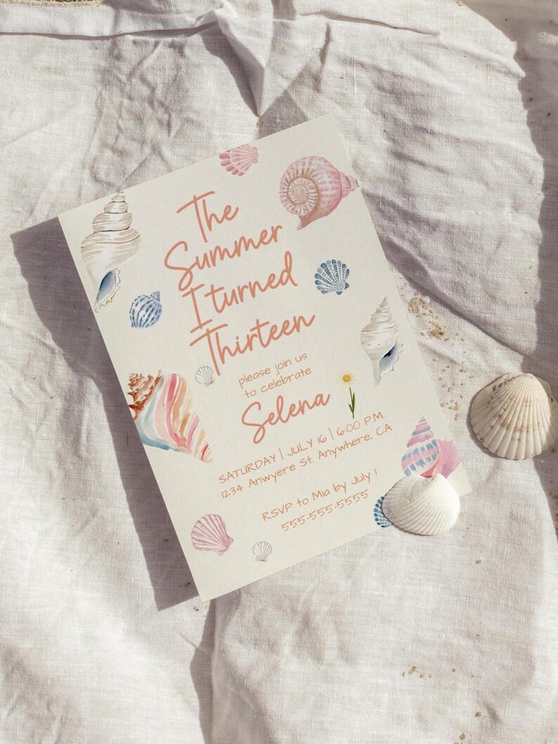 Pu&ograve; includere: Un invito color crema con illustrazioni di conchiglie ad acquerello e il testo "The Summer I turned Thirteen" in corallo. L'invito include i dettagli dell'evento e conchiglie.