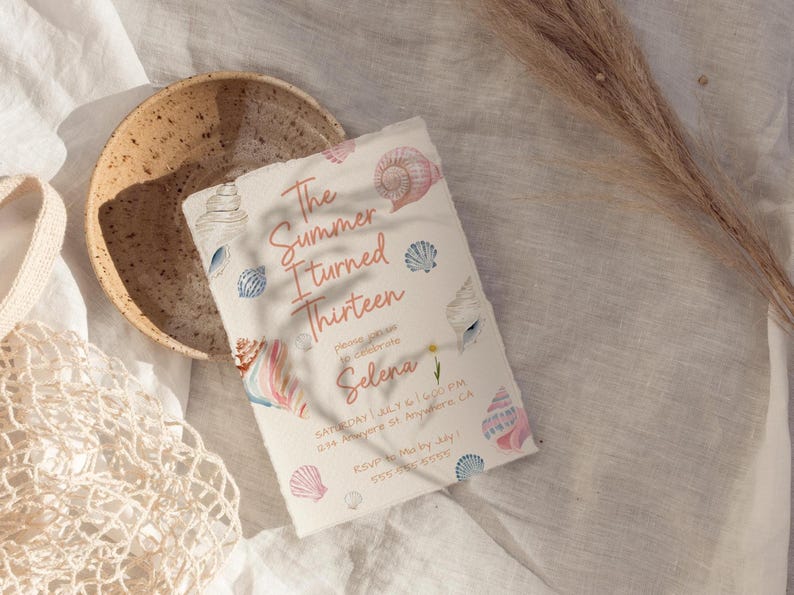 Pu&ograve; includere: Un invito di compleanno a tema conchiglie. Il testo recita "The Summer I Turned Thirteen" in corsivo rosa, con ulteriori dettagli in basso. Illustrazioni di conchiglie rosa, blu e bianche decorano l'invito. Una ciotola beige e una borsa a rete sono sullo sfondo.