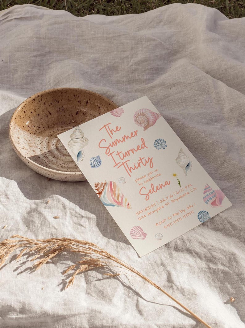 Puede incluir: Una invitaci&oacute;n de cumplea&ntilde;os con ilustraciones de conchas marinas y el texto "The Summer I Turned Thirty" en rosa. La invitaci&oacute;n incluye detalles de la fiesta, con un cuenco de cer&aacute;mica moteada en el fondo.