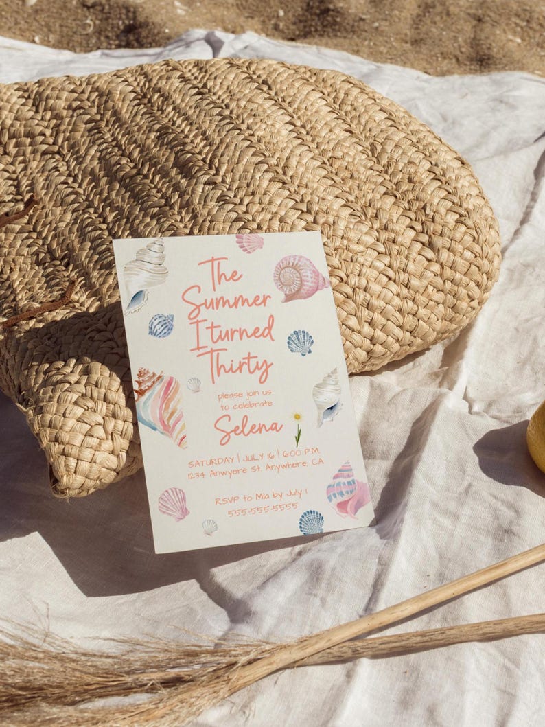 Puede incluir: Una bolsa de paja tejida beige descansa sobre una tela blanca junto a una invitaci&oacute;n de fiesta. La invitaci&oacute;n presenta ilustraciones de conchas marinas en acuarela y el texto "The Summer I turned Thirty" con detalles del evento.