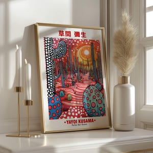 May include: A framed art print featuring a desert landscape with cacti and a sun, in a style reminiscent of Yayoi Kusama. The artwork uses red, blue, and white polka dots. The text "YAYOI KUSAMA Polka Dot Queen" is visible.